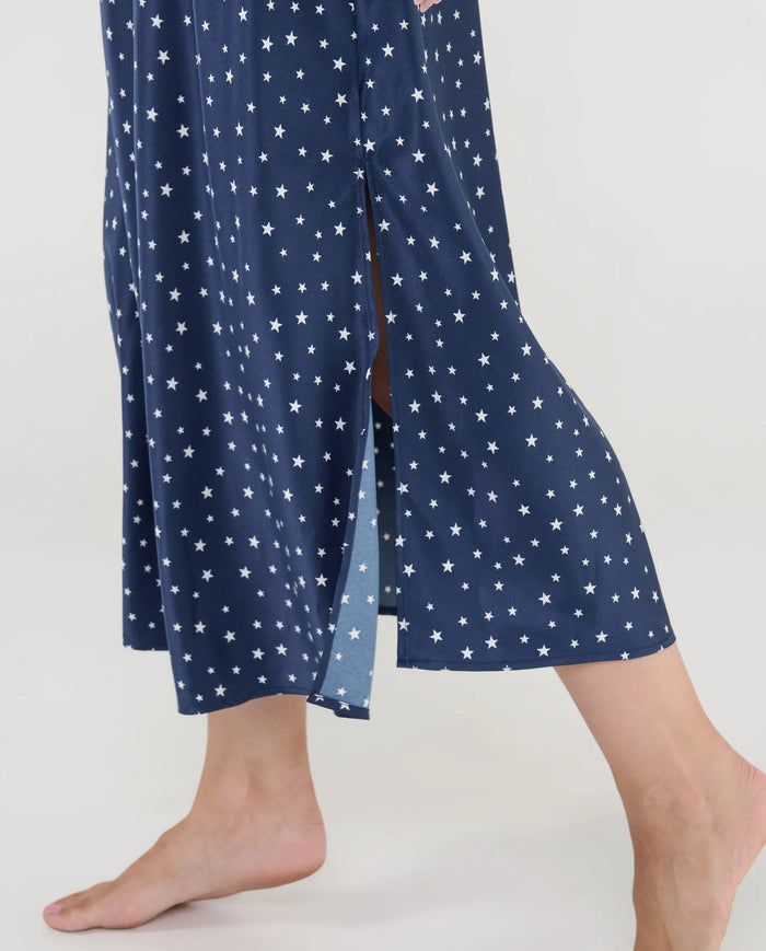 Primer plano del delicado tejido de raso con estampado de estrellas y finos tirantes regulables.