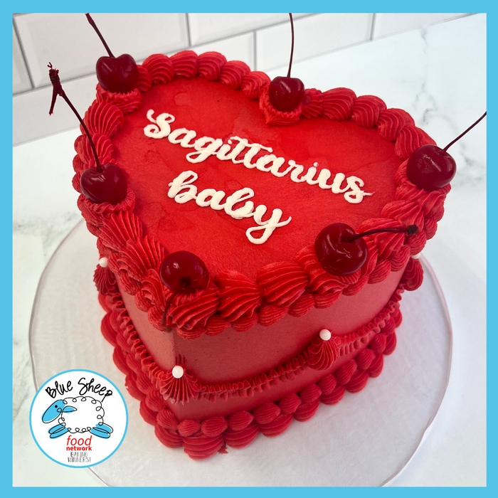 Heart-shaped birthday cake with script astrological sign
