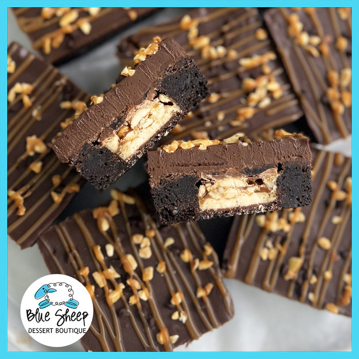 Gourmet stuffed Snickers brownies with caramel drizzle and nut topping