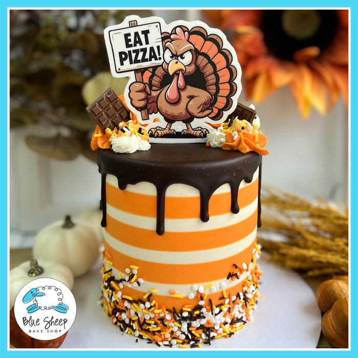 Thanksgiving cake with chocolate drip, festive sprinkles, and a humorous turkey topper saying 'Eat Pizza'