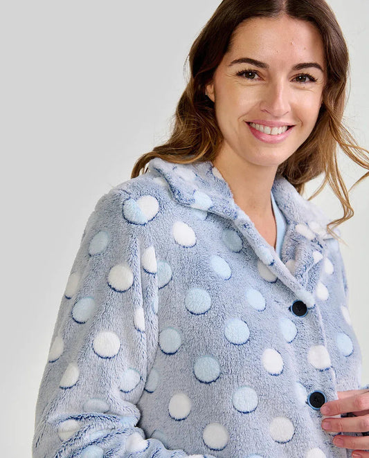 Mujer luce suave bata de invierno corta abotonada en azul claro con lunares