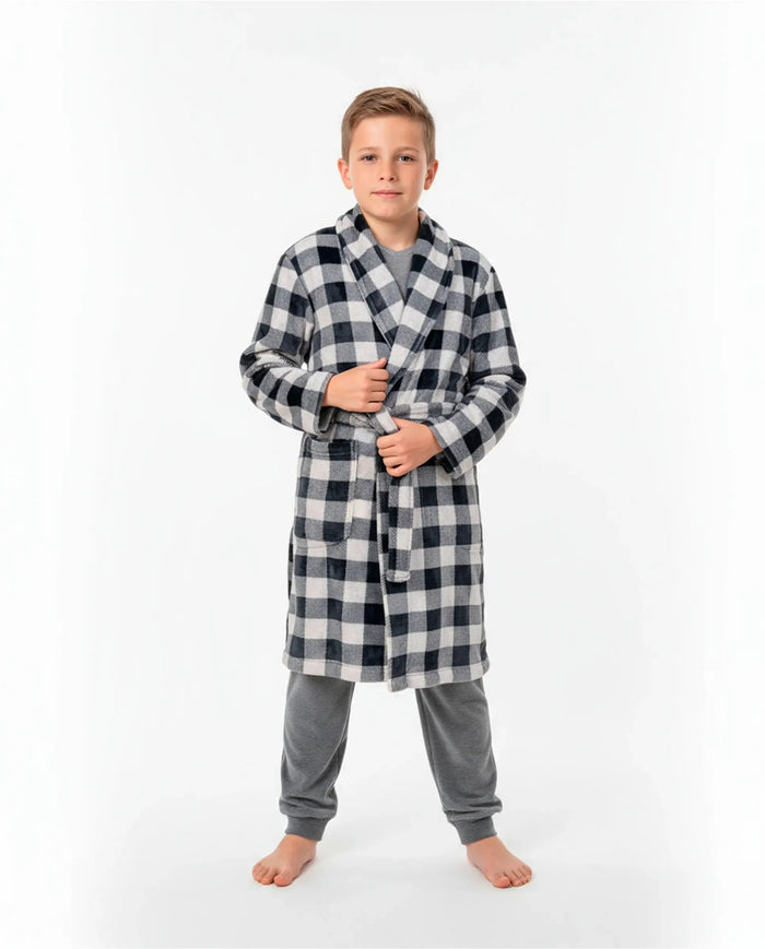 Niño con bata cruzada de invierno a cuadros negra y blanca sobre pijama gris de terciopelo