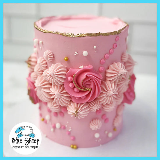 pink buttercream birthday cake with florals