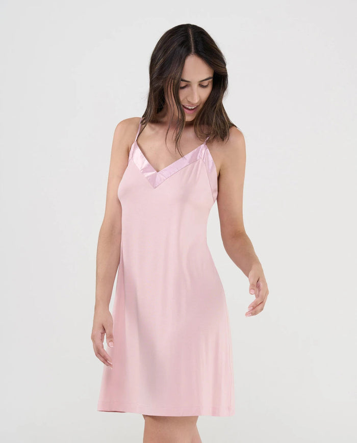 Mujer con camisón corto de tirantes finos en suave modal rosa palo con cuello pico de raso a juego
