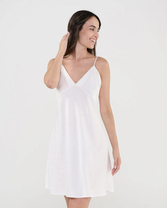 Mujer luce camisón lencero de suave tejido plana marfil con topos de raso, escote pico y tirantes