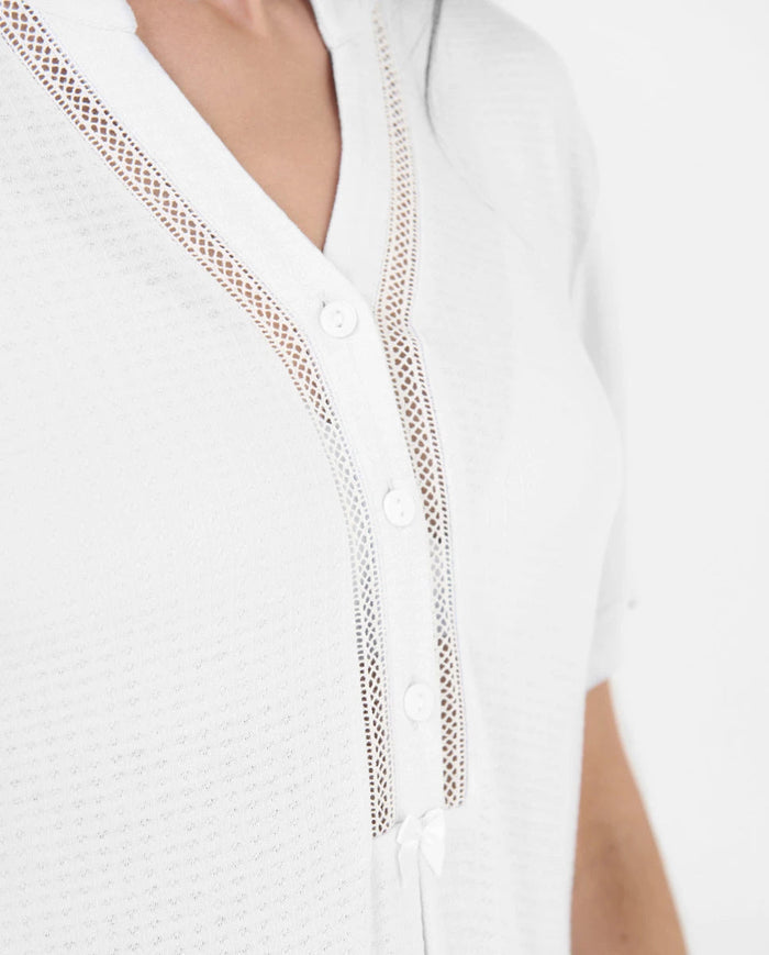 Detalle del escote pico con botones y entredós del camisón lencero marfil
