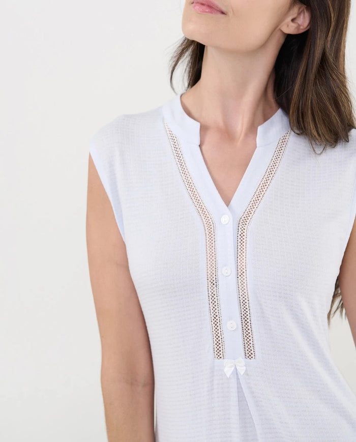 Detalle del cuello pata celeste abotonado con entredós y lazo decorativo.