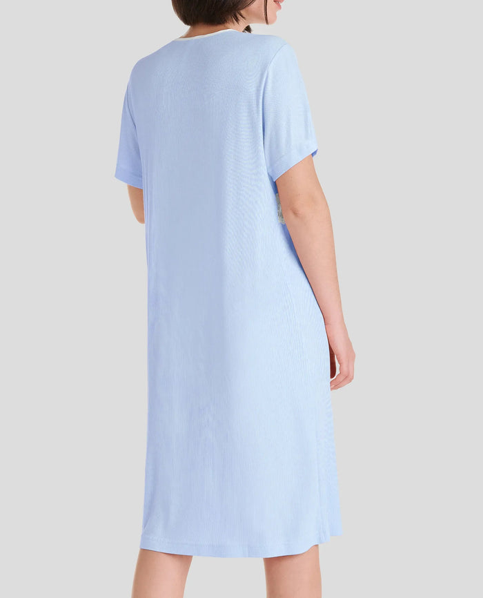 Vista trasera mujer con camisola de verano celeste de manga corta