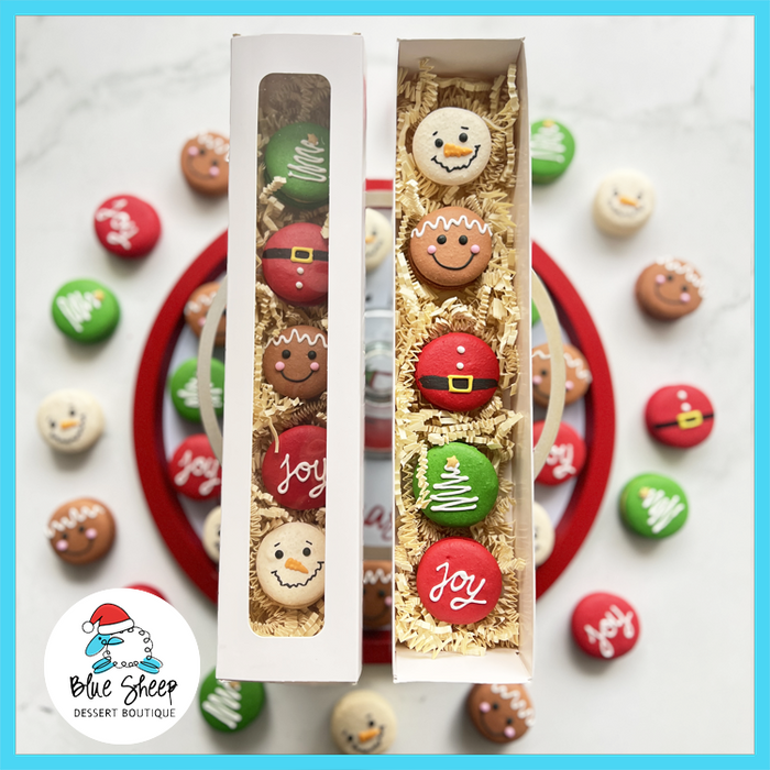 Decorative Christmas French macarons  in a gift box with Christmas-themed designs on a white background.