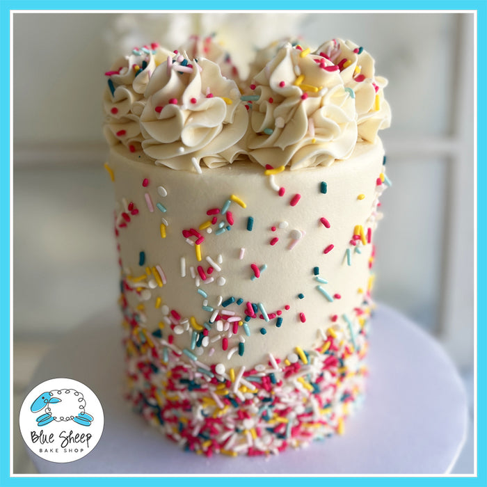 Vanilla cake with rainbow sprinkles and buttercream swirls by Blue Sheep Bake Shop.