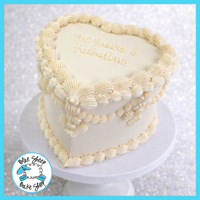 Elegant heart-shaped buttercream cake with piped borders for milestone birthdays and anniversaries made by Blue Sheep Bake Shop in Somerville NJ