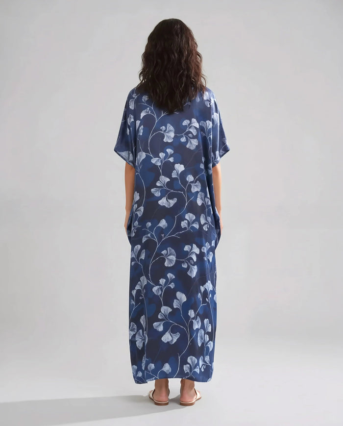 Mujer de espaldas con caftan de seda natural marino largo hasta los tobillos