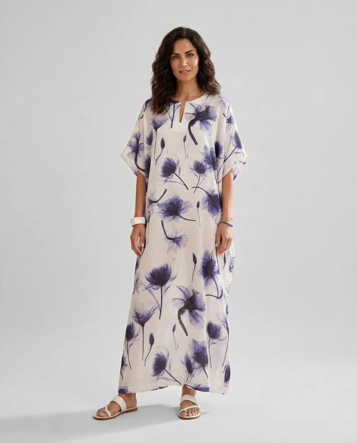 Mujer viste elegante caftan de seda natural blanco estampado de flores azules