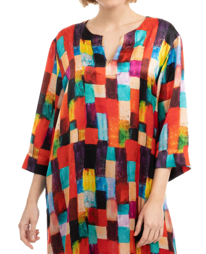 Detalle cuello abierto de kaftan de seda estampado geométrico