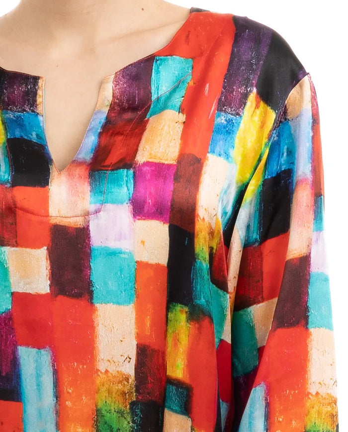Detalle cuello abierto de kaftan de seda estampado geométrico