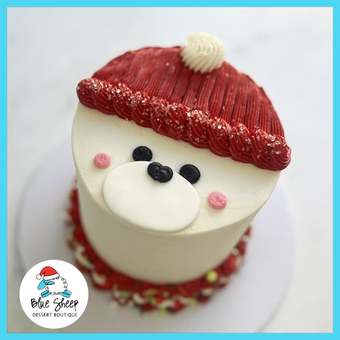 Holiday Bear Christmas Cake with buttercream bear face, red winter hat, and festive decorations made by Blue Sheep Bake Shop in Somerville NJ.