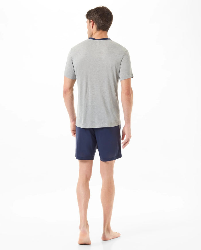 Vista trasera de hombre con pijama veraniego corto gris y pantalón marino