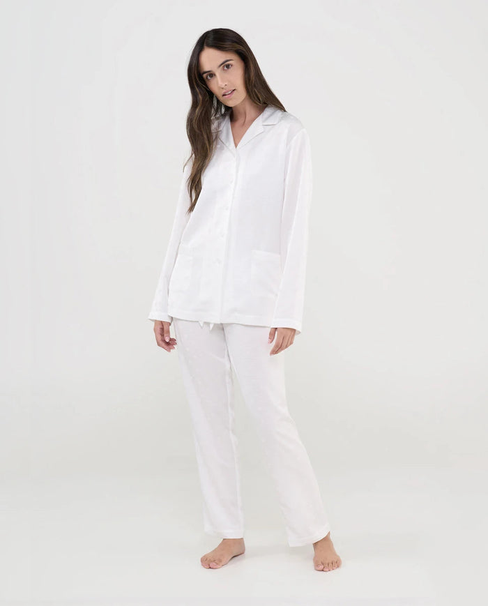 Mujer con pijama estilo camisero abierto, botones color marfil, cuello solapa y estampado de topos en raso.