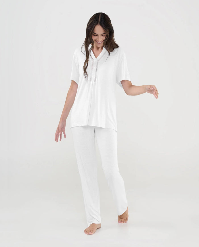 Mujer con pijama lencero de verano color marfil de manga corta y pantalón largo con escote pico y detalle entredós
