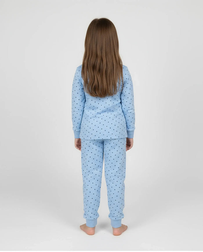 Niña de espaldas con cómodo y calentito pijama de invierno azul claro con topitos grises