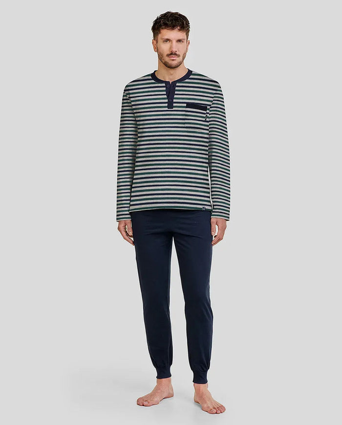 Hombre viste pijama de invierno con  camiseta de manga larga a rayas y pantalón azul marino
