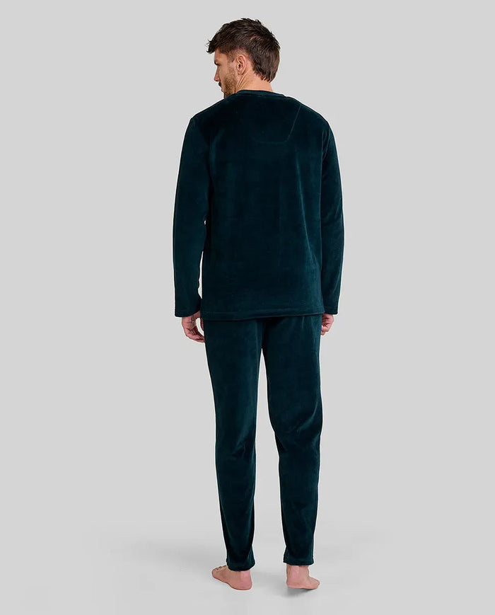 hombre de espaldas con confortable pijama largo de terciopelo liso verde con bolsillos laterales