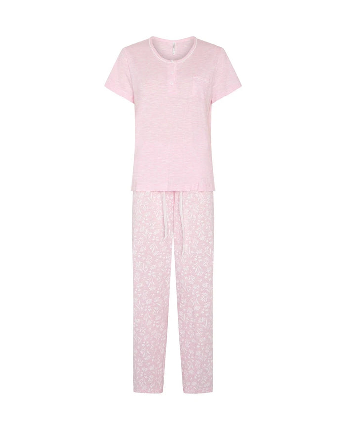 Pijama largo de mujer en punto, con camiseta flamé rosa de manga corta y cuello redondo con botones y pantalón estampado de florecitas blancas.