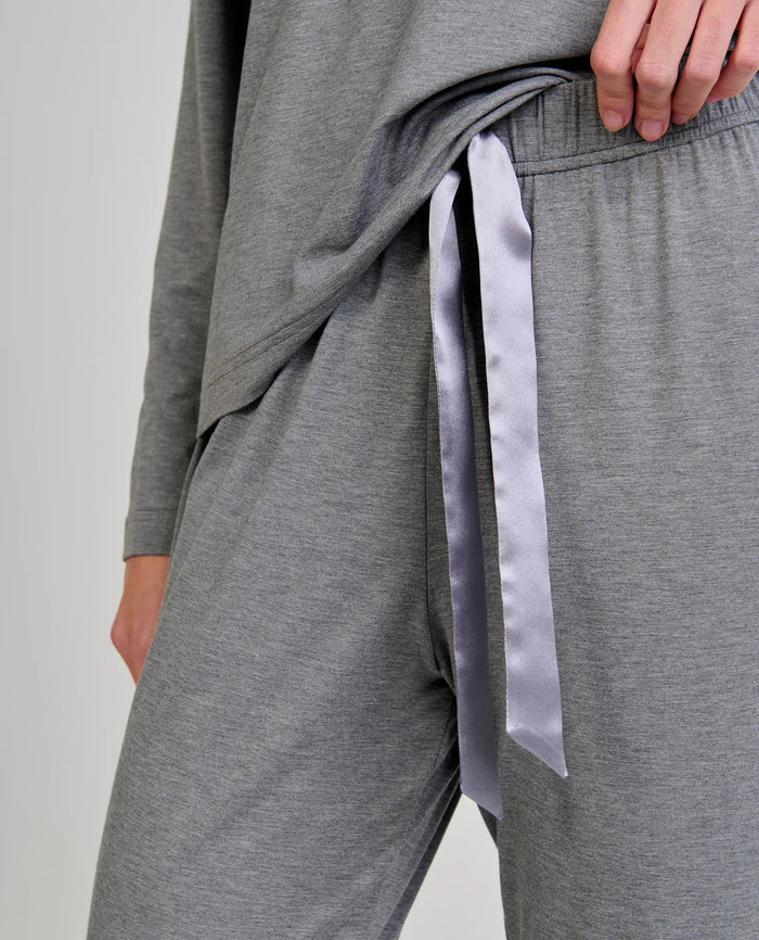 Detalle del pantalón de pijama largo gris con lazo de raso en la cintura.