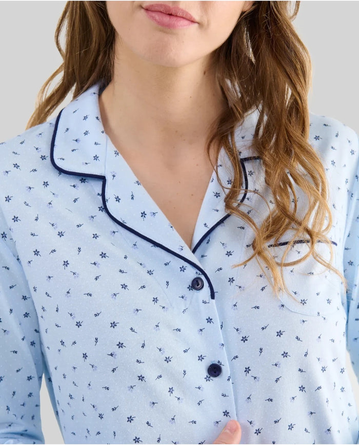 Detalle del cuello del pijama camisero celeste estampado florecitas con vivo y botones en contraste marino