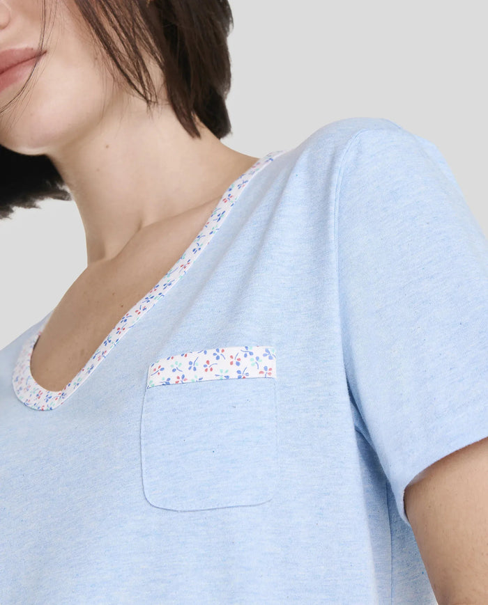 Detalle de camiseta de pijama de manga corta azul con detalles de florecillas en cuello pico y bolsillo