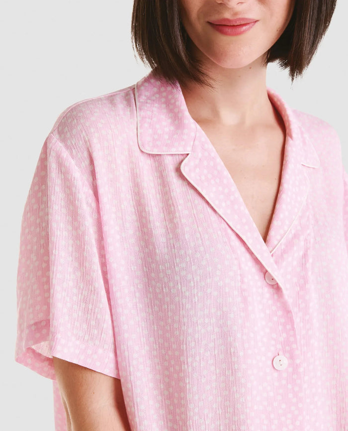 Detalle de chaquetilla de pijama abierta con botones de manga corta en viscosa rosa con topitos