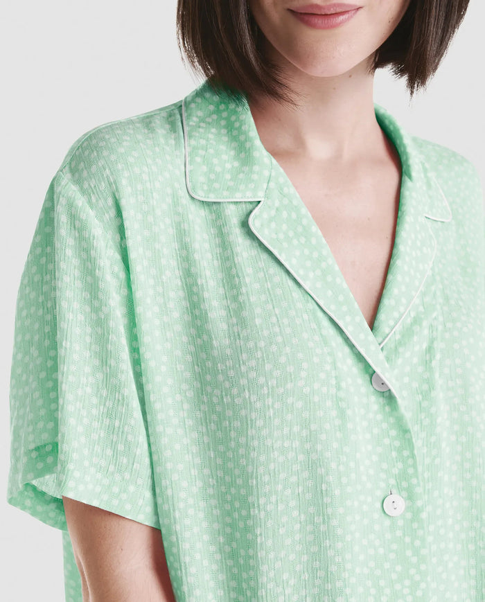Detalle de chaquetilla de pijama abierta con botones de manga corta en viscosa verde con topitos