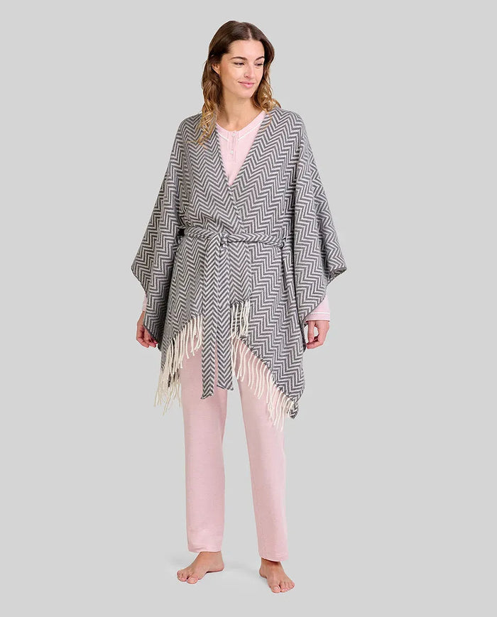 Mujer con pijama rosa claro y poncho  gris con flecos y cinturón