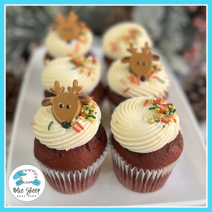 Rudolph-themed red velvet Christmas cupcakes with vanilla buttercream frosting and holiday sprinkles.