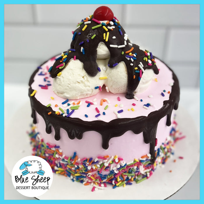 A soft pink ice cream birthday cake with sprinkles and a chocolate drizzle, topped with scoops of ice cream and a cherry.