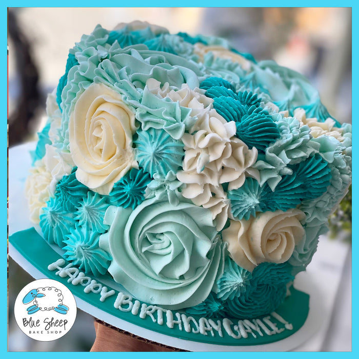 Gluten-free birthday cake with hand-piped buttercream flowers in blue and white, featuring elegant floral textures and a custom message, available at Blue Sheep Bake Shop in Somerville, NJ