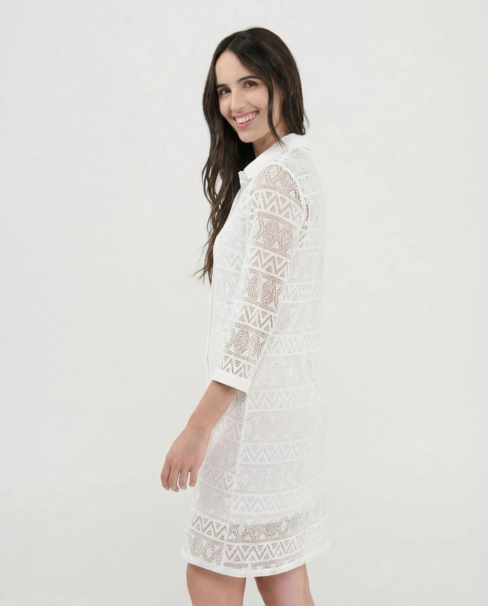 Vista lateral de mujer con vestido playero de punto desagujado blanco