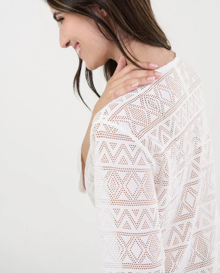 Detalle de punto desagujado con motivos geométricos del vestido playero blanco