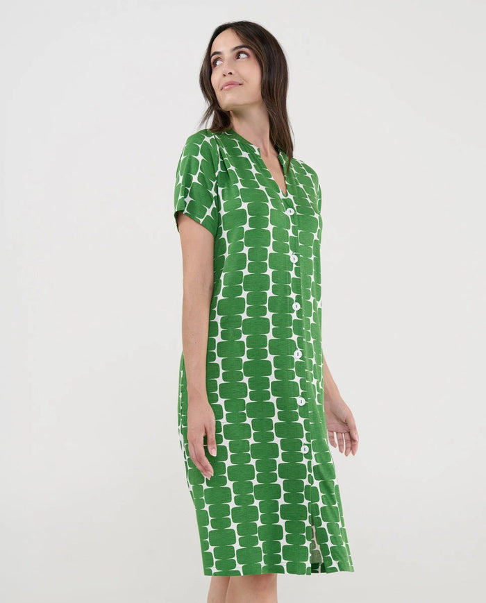 Mujer con vestido playero verde de manga corta abotonado y patrón geométrico blanco.