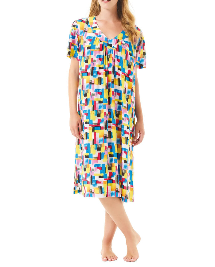 Mujer luce vestido de verano de manga corta y colorido estampado geométrico