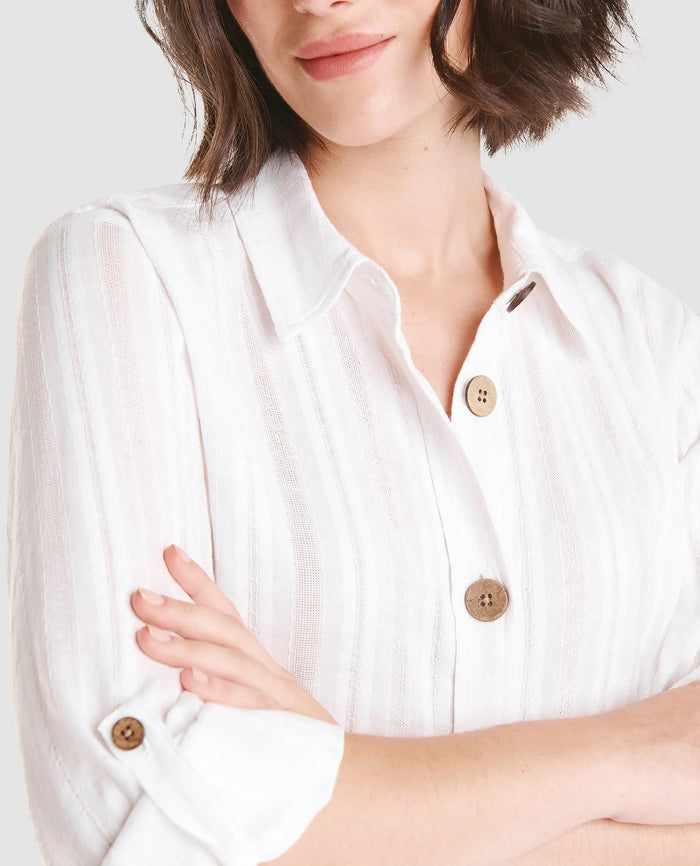 Mujer luce vestido largo abotonado color blanco con cuello camisero y sombrero de paja